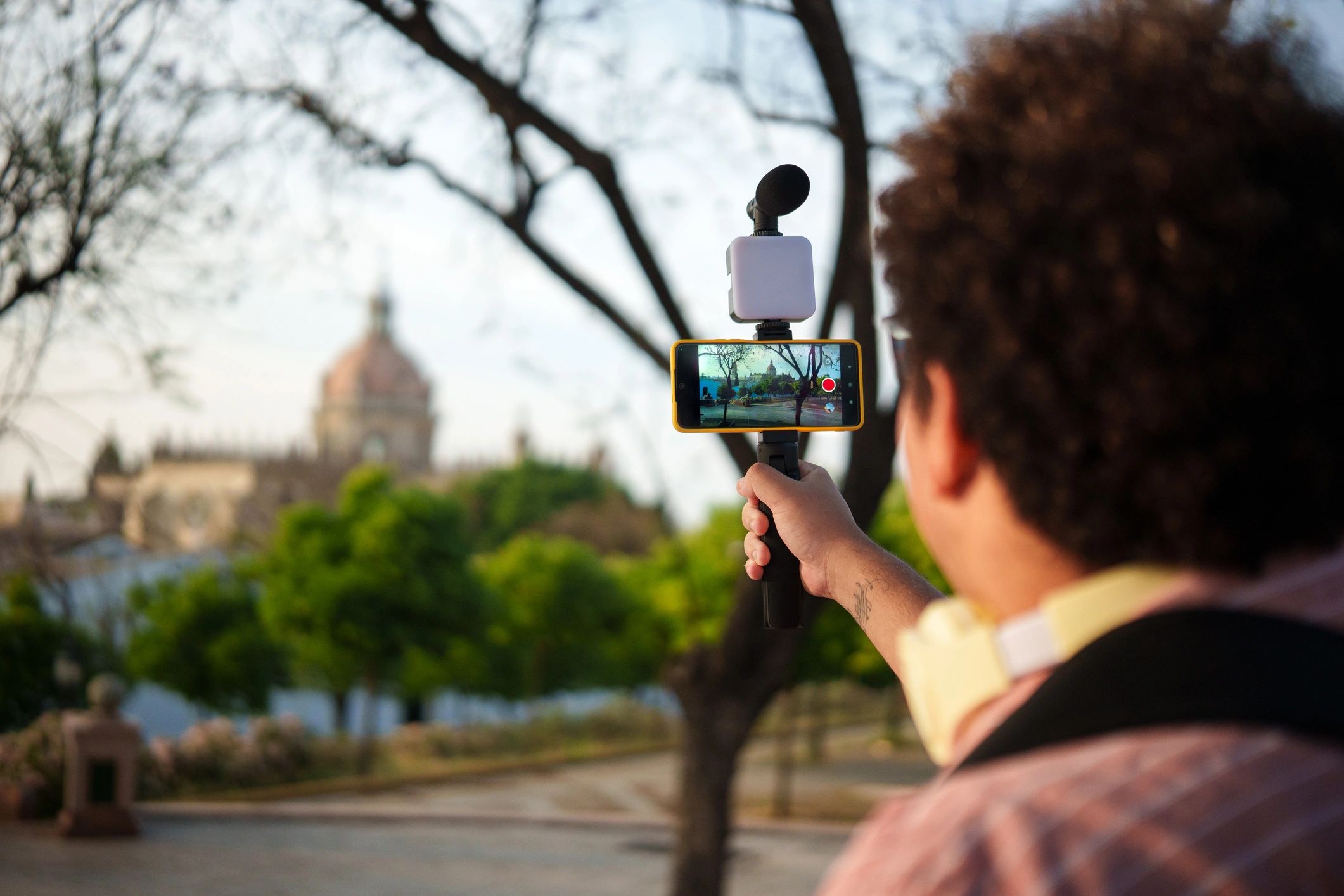 Creator filming with smartphone gimbal representing content production
